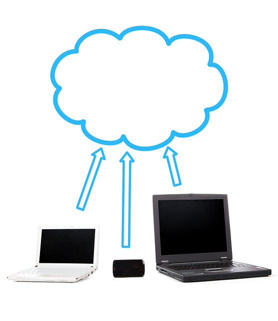 Cloud computing illustration with two laptops and a smartphone connected to a cloud via blue arrows, symbolizing file sharing.