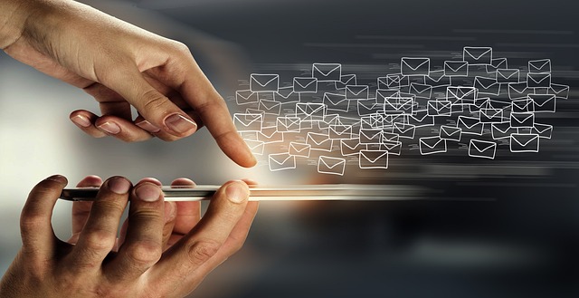 A person using a smartphone with multiple email icons flying out symbolizes sending a large volume of emails.