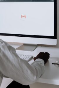 A person sitting in front of a computer with the Gmail app loading on the scree. 