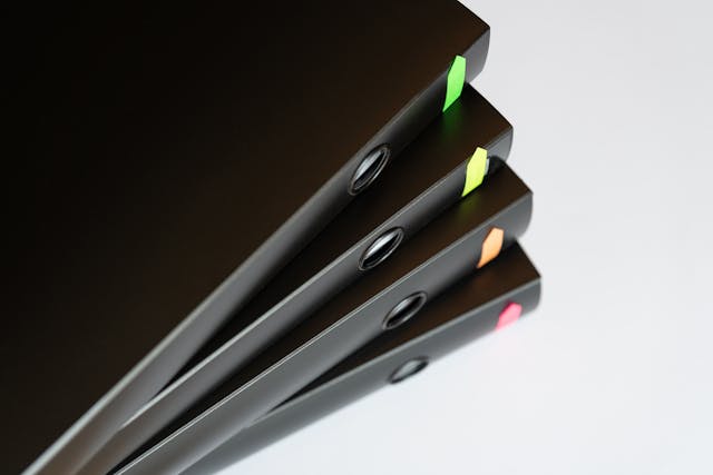 Stack of black file folders with colorful tabs for easy organization and retrieval