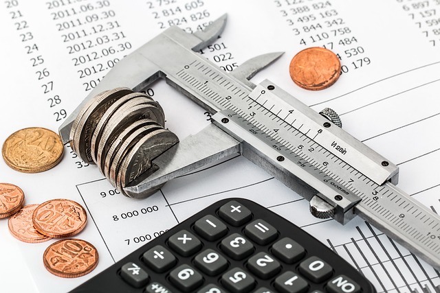 A caliper measuring a stack of coins on financial documents.