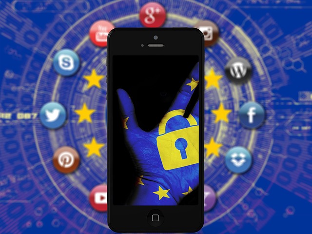 A smartphone displaying a hand with GDPR lock and EU stars, surrounded by social media icons.