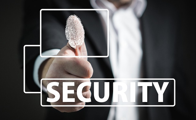 A person in a suit pressing their thumb on a digital interface with a fingerprint icon, overlaid with the word "SECURITY."