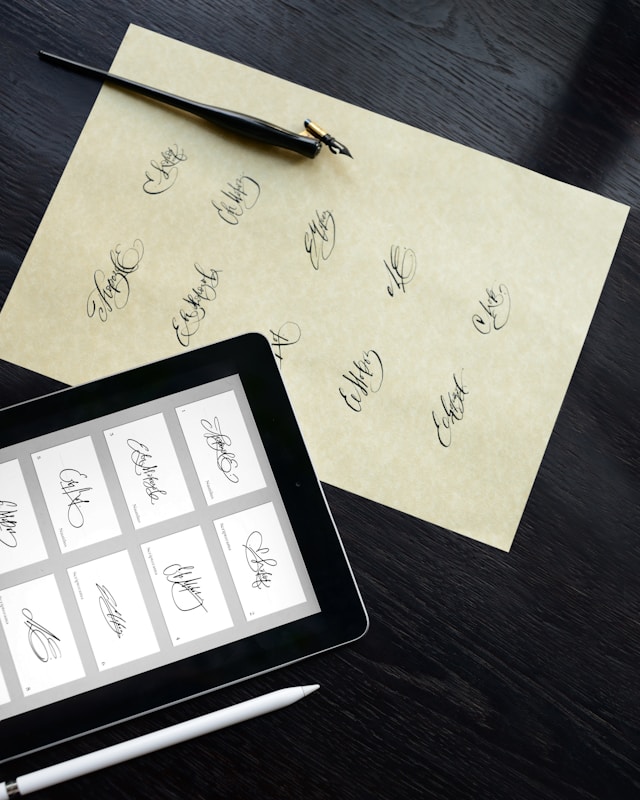 A tablet displaying digital signature options next to a paper with handwritten signatures and a fountain pen.